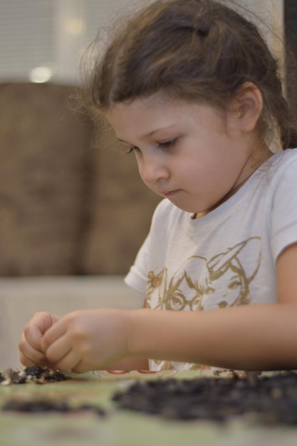 The girl peel sunflower seeds a large portrait view from the front