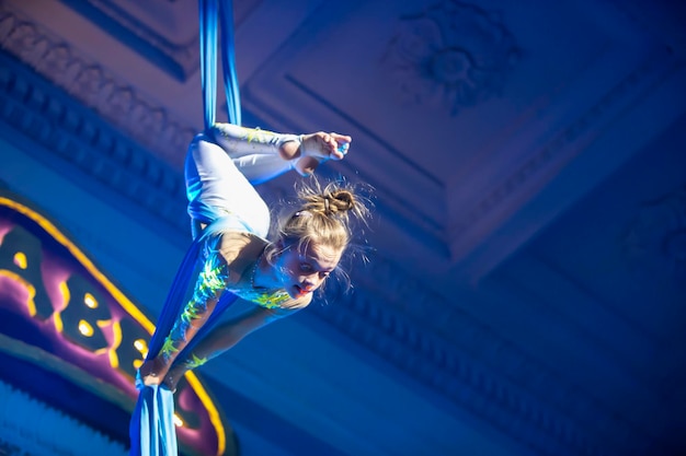 The girl performs acrobatic numbers on the canvases