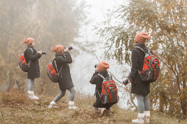 女の子の写真家は、秋の自然の写真を撮ります。