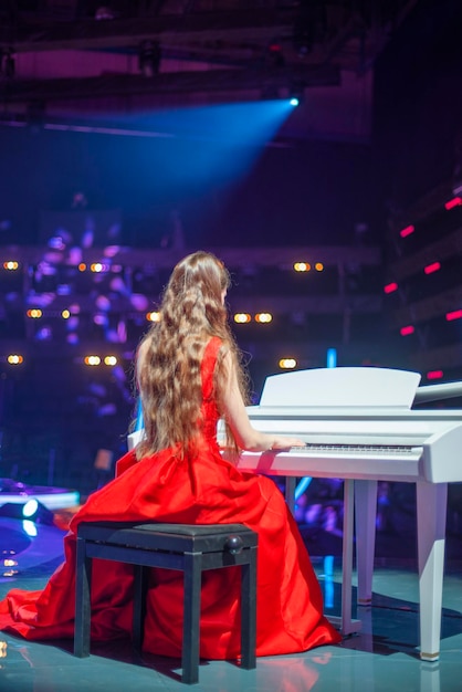 Foto ragazza al pianoforte sul palco