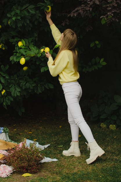 写真 庭でレモンを摘む女の子