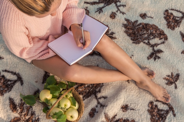 Girl on a picnic on the nature rests on a blanket of blankets