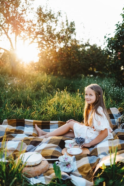 Photo a girl on a picnic at sunset in the garden