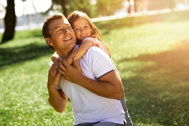 Girl piggyback riding man in the park spending time together