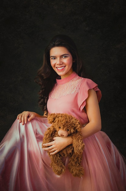 Ragazza con un vestito rosa e un orsacchiotto