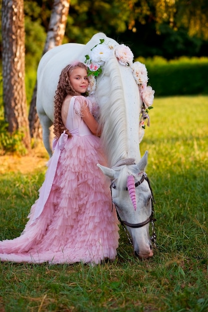 Ragazza in abito rosa con cavallo bianco