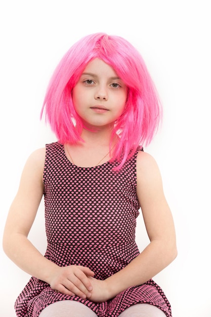 Girl in pink hair wig isolated on white. Beauty and hairdressing salon. Fashion and style. Child and childhood. Holiday celebration concept.