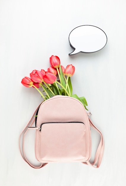 Girl pink lether back pack with red tulips and speech bubble light box.