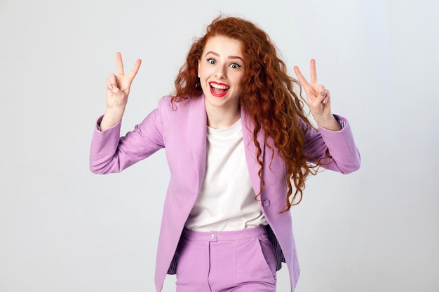 Girl in pink suit showing v sign or peace