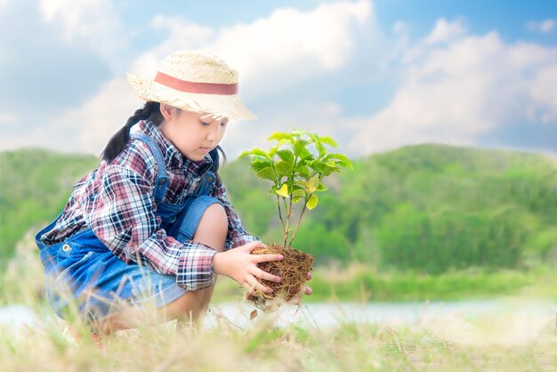 Girl planting on field against sky