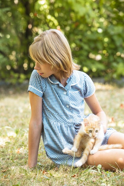 La ragazza gioca con il gattino all'aperto nel parco