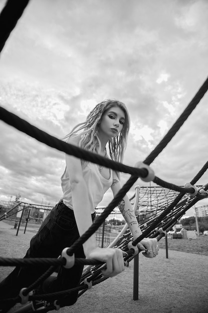 A girl on a playground with a cloudy sky behind her