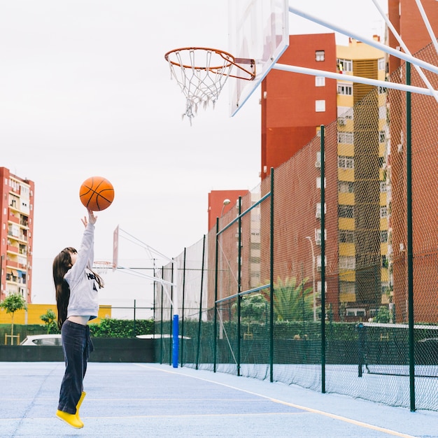 Фото Девушка играет в баскетбол на спортивной площадке