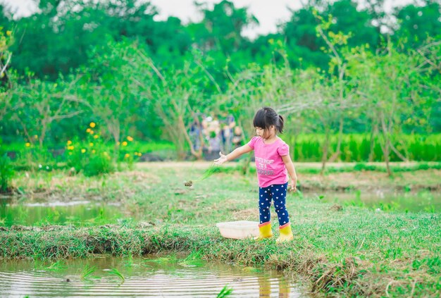 Girl playing by lake on grassy field