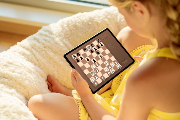 Premium Photo  Girl playing chess online on tablet computer