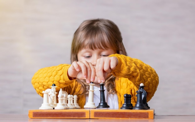 Photo girl playing chess at the table