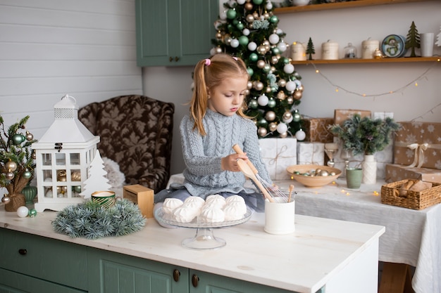 Ragazza che gioca nella cucina del mattino di natale a casa