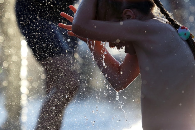 Girl playing in the fountain drops