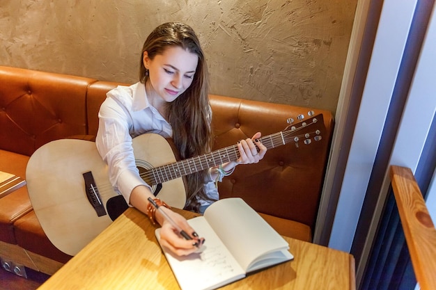 Girl playing guitar at cafe