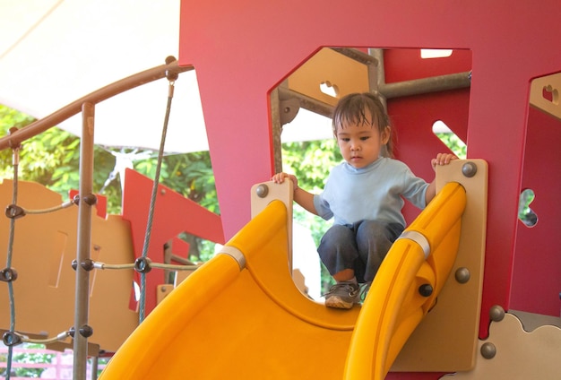 写真 遊び場でスライドで遊んでいる女の子