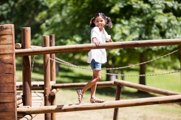 Girl playing on a playground ride in park