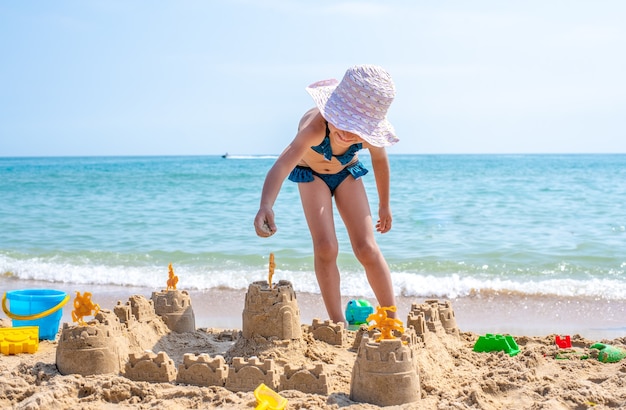 Girl playing on a sandy beach on summer vacation A child is building a sand castle on the sea