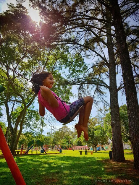 Girl playing on swing at park