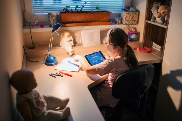 Ragazza che gioca tablet gioco al tavolo