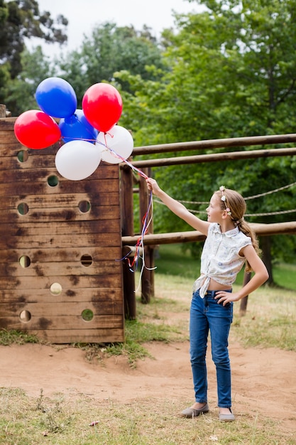 Girl playing with balloons at park