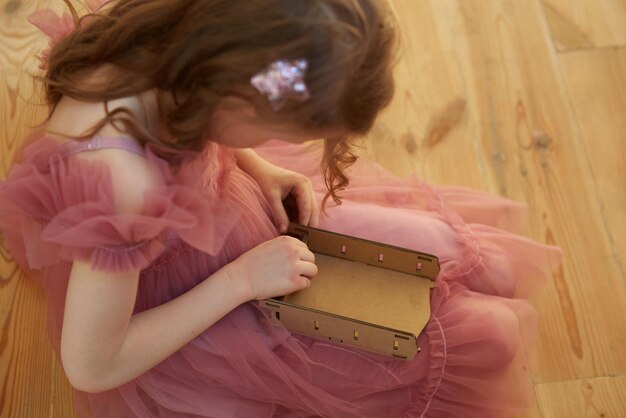 A girl playing with cardboard toy dollhouse furniture