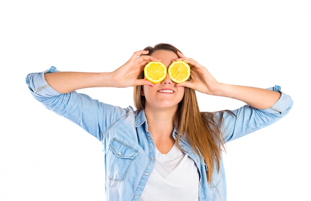 Girl playing with lemon over white background