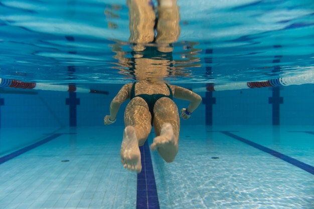 Foto una ragazza fa sport in una piscina sottomarina vista foto da dietro