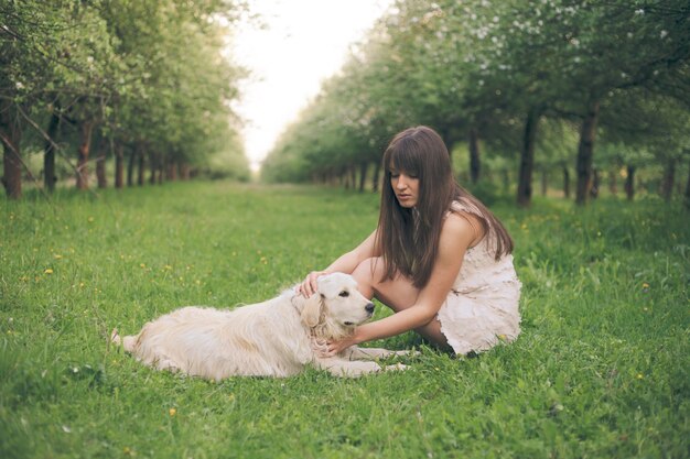 Girl plays with golden retriever in the park