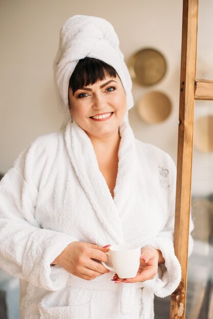 Girl plus size in robe and turban spa smile