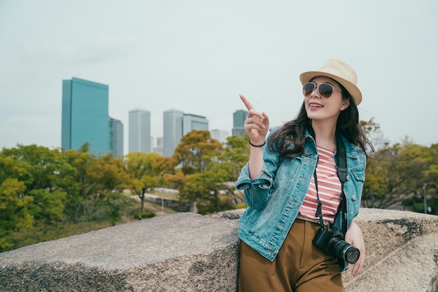 Girl pointing to sky with background skyscraper