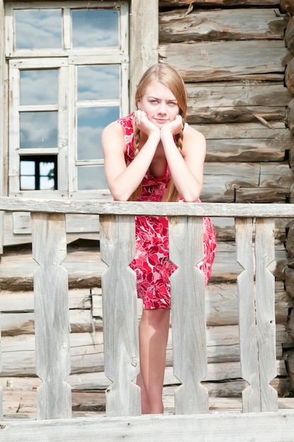 Girl on the porch of an old wooden house