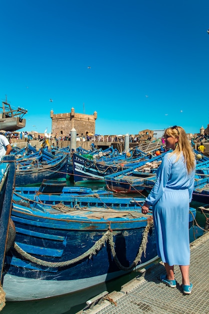 Essaouira의 항구에있는 여자. 유명한 블루 보트