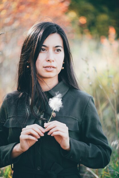 Girl portrait with flower on autumn bokeh background.