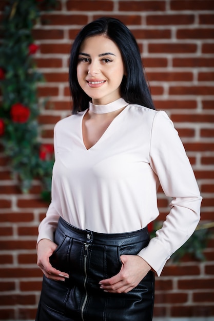 Girl poses beautifully against a brick wall