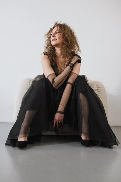 Girl posing in a black dress on a white background