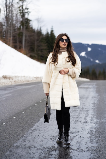 Girl posing on road on winter woods