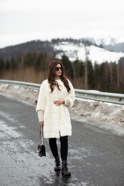 Girl posing on road on winter woods 