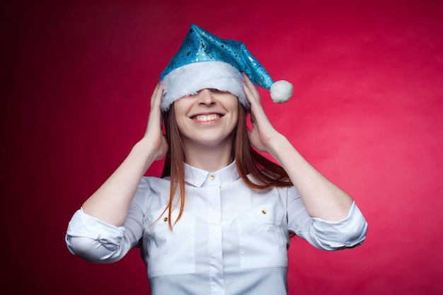 Girl posing in the Studio on a pink background in a Christmas hatxA