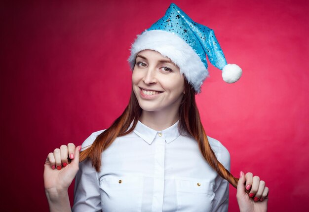 Girl posing in the Studio on a pink background in a Christmas hatxA