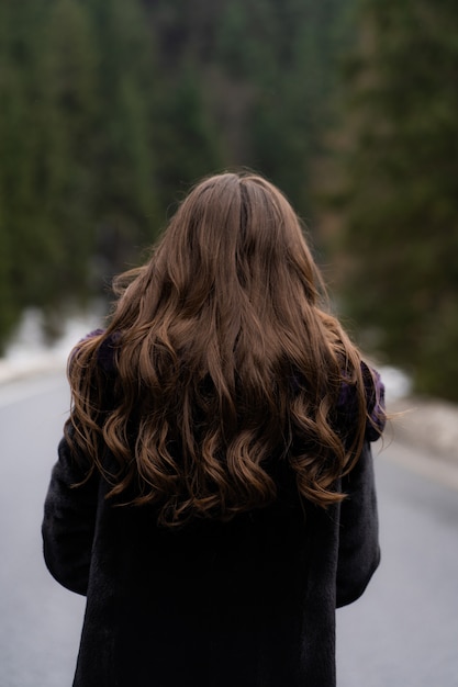 Girl posing and turn around at camera on winter woods