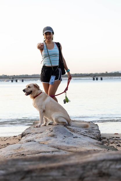 girl posing with the dog on the beach