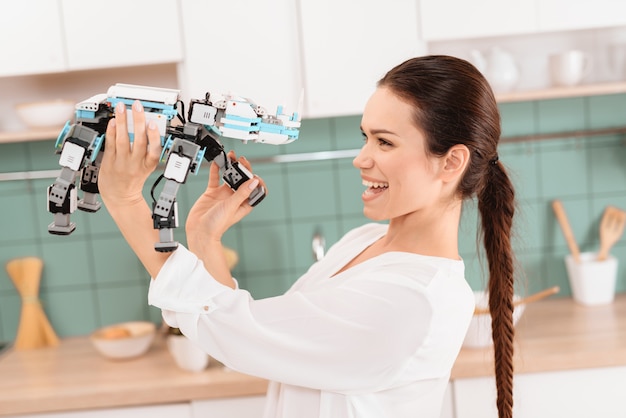 Ragazza che posa con un robot di rinoceronte in una bella cucina moderna.