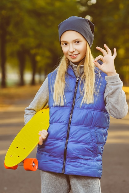 Girl posing with skateboard outdoor
