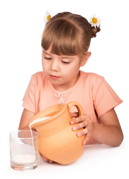 Girl pours milk from a jug on a white background