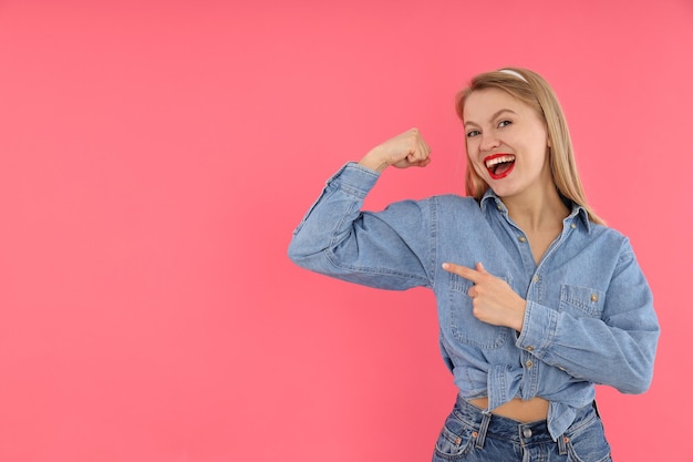 ピンクの背景に若い女性と女の子の力の概念